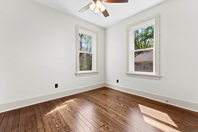 empty room with a ceiling fan, baseboards, and dark wood finished floors
