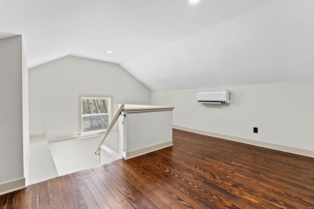 additional living space with vaulted ceiling, wood finished floors, a wall mounted AC, and recessed lighting