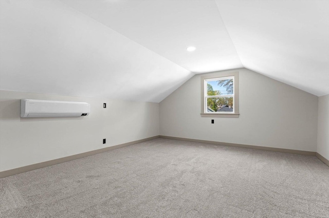 additional living space featuring lofted ceiling, light carpet, baseboards, and a wall mounted AC