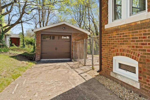 detached garage with concrete driveway and fence