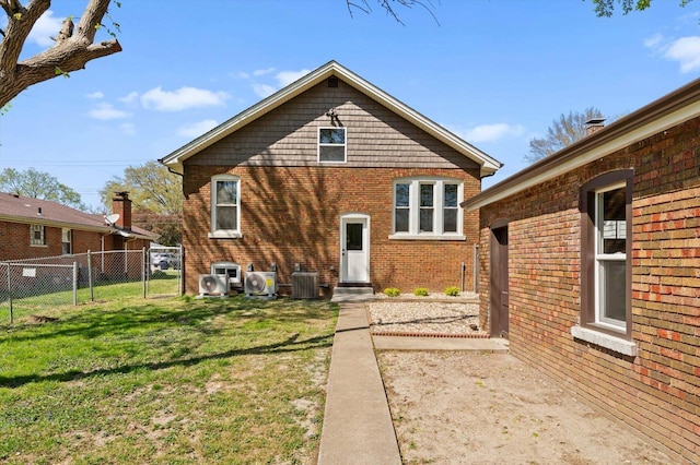 rear view of house featuring a gate, a lawn, fence, cooling unit, and brick siding