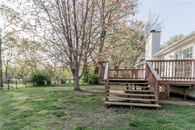 view of yard with a wooden deck, stairs, and fence