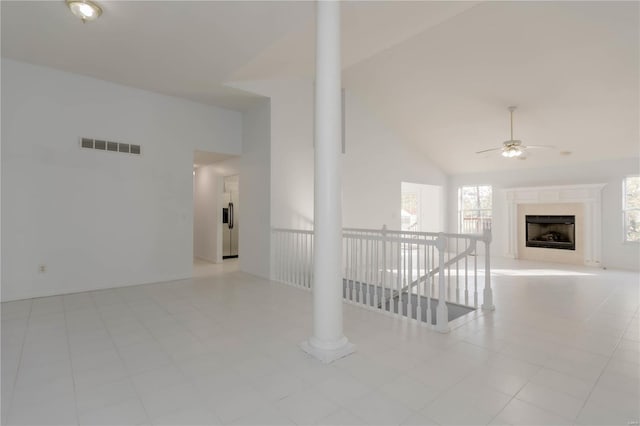 interior space with a fireplace, visible vents, high vaulted ceiling, and ceiling fan