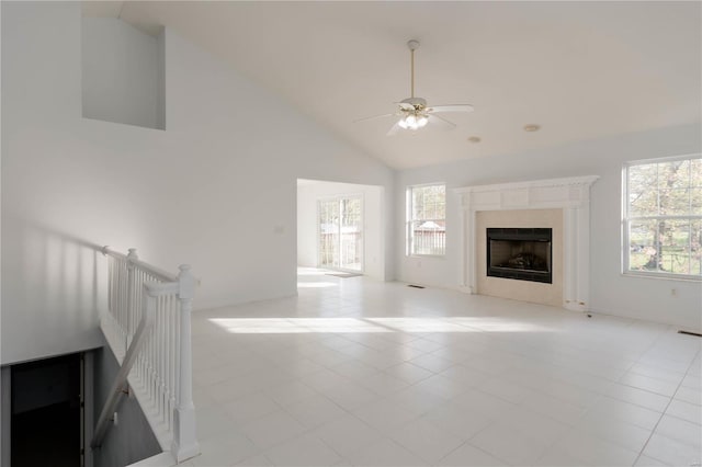 unfurnished living room with a premium fireplace, a ceiling fan, high vaulted ceiling, and light tile patterned flooring