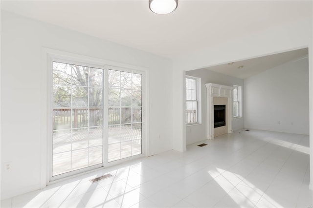 unfurnished living room featuring a fireplace, visible vents, and tile patterned flooring