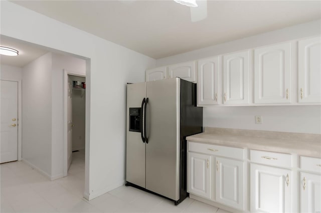kitchen with white cabinets, light countertops, stainless steel refrigerator with ice dispenser, and light tile patterned flooring