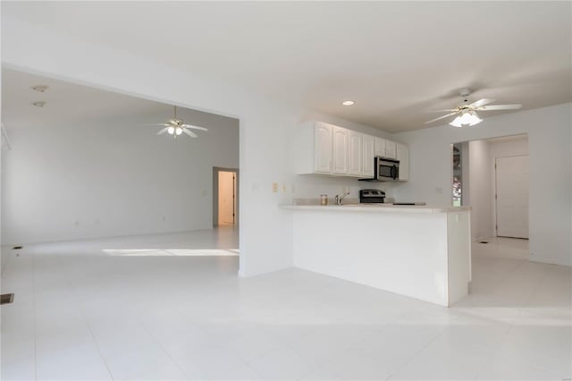 kitchen featuring open floor plan, ceiling fan, appliances with stainless steel finishes, and light countertops