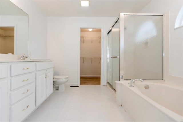 full bathroom featuring tile patterned floors, a stall shower, a garden tub, vanity, and a walk in closet