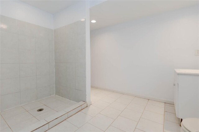 bathroom featuring recessed lighting, a tile shower, toilet, and vanity