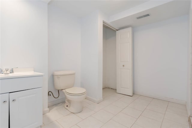 bathroom with toilet, vanity, visible vents, and baseboards