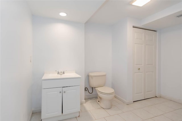 bathroom with baseboards, toilet, vanity, and visible vents