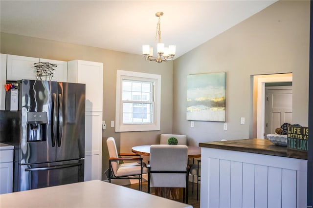 dining room with vaulted ceiling and a notable chandelier