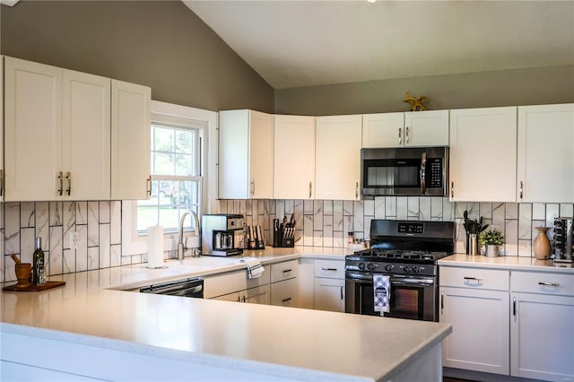 kitchen with stainless steel microwave, vaulted ceiling, black gas stove, and light countertops