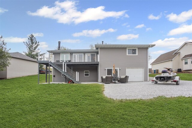 rear view of property featuring stairway, a garage, a yard, driveway, and a deck