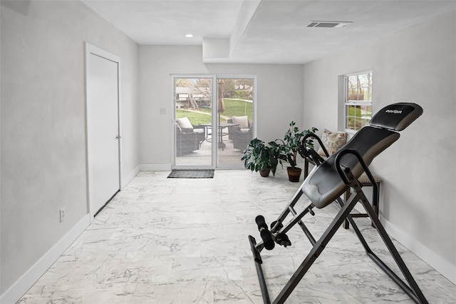 exercise area with a healthy amount of sunlight, marble finish floor, baseboards, and visible vents