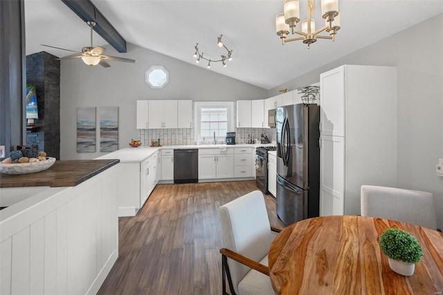 kitchen featuring lofted ceiling with beams, stainless steel fridge, wood finished floors, dishwashing machine, and black range with gas cooktop