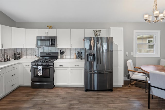 kitchen featuring a chandelier, decorative backsplash, white cabinetry, and stainless steel appliances