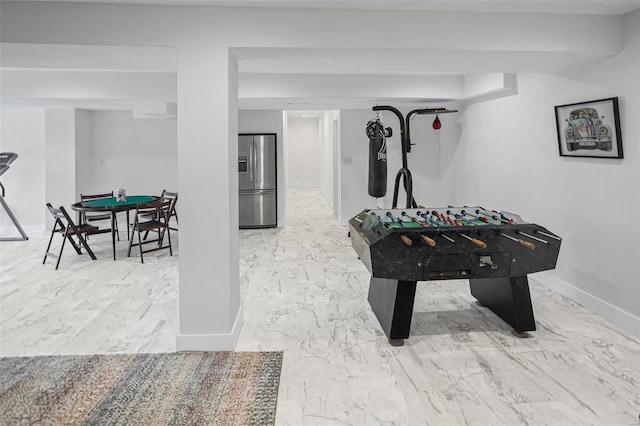 playroom with marble finish floor and baseboards