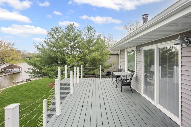 wooden terrace featuring a lawn and a water view