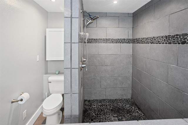 full bathroom with recessed lighting, baseboards, toilet, and tiled shower