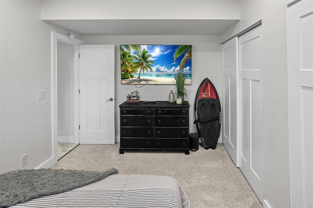 bedroom with baseboards, carpet floors, and a closet