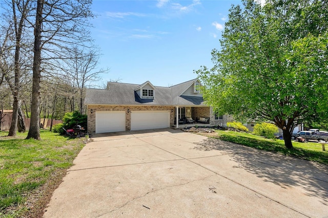 view of front facade with fence, concrete driveway, an attached garage, brick siding, and a front yard