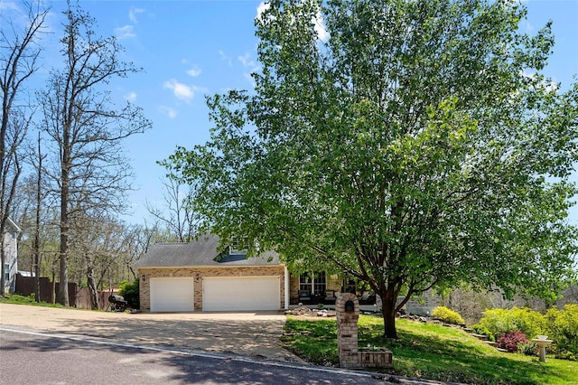 obstructed view of property with a garage, driveway, and brick siding