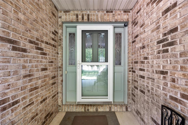 view of exterior entry with brick siding