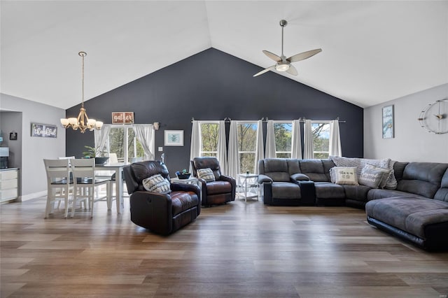 living area featuring ceiling fan with notable chandelier, wood finished floors, high vaulted ceiling, and a healthy amount of sunlight
