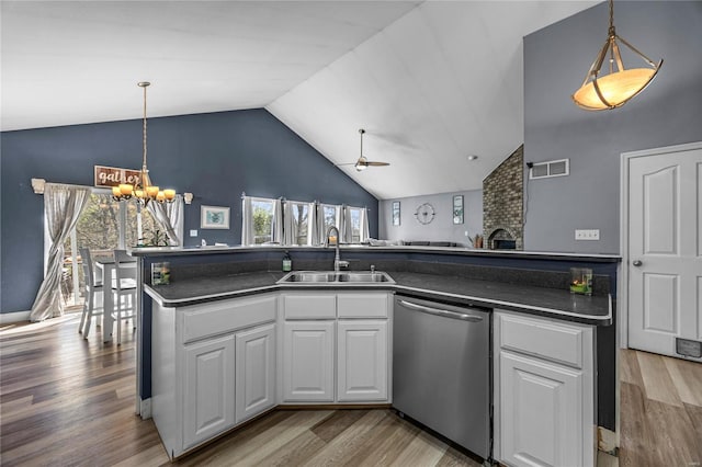 kitchen with dark countertops, dishwasher, visible vents, and a sink
