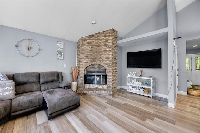 living room with a fireplace, lofted ceiling, and wood finished floors