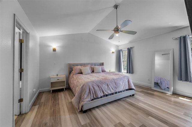 bedroom featuring lofted ceiling, wood finished floors, visible vents, a ceiling fan, and baseboards