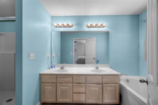 full bath featuring a bath, double vanity, connected bathroom, and a sink