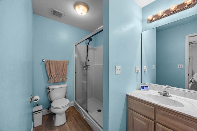 full bathroom with wood finished floors, a stall shower, vanity, toilet, and visible vents