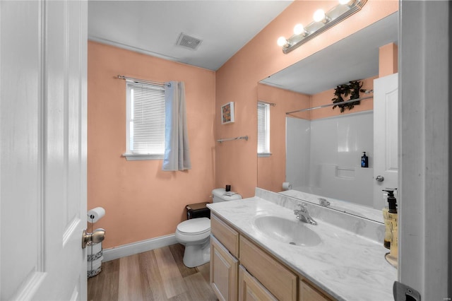 bathroom featuring wood finished floors, vanity, walk in shower, baseboards, and visible vents