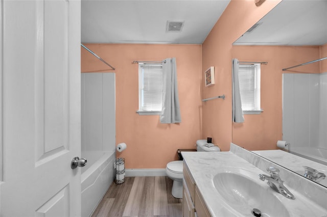 full bathroom with wood finished floors, shower / bath combination, vanity, toilet, and baseboards