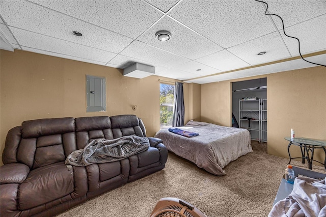 carpeted bedroom featuring electric panel and a drop ceiling