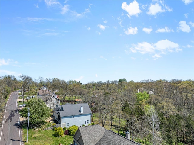 drone / aerial view featuring a wooded view