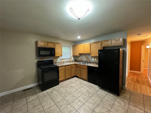 kitchen with tasteful backsplash, baseboards, black appliances, light countertops, and light tile patterned floors