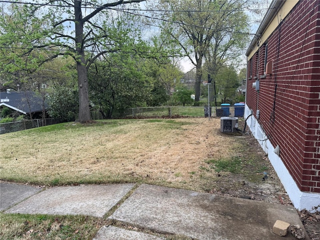 view of yard with central AC and fence