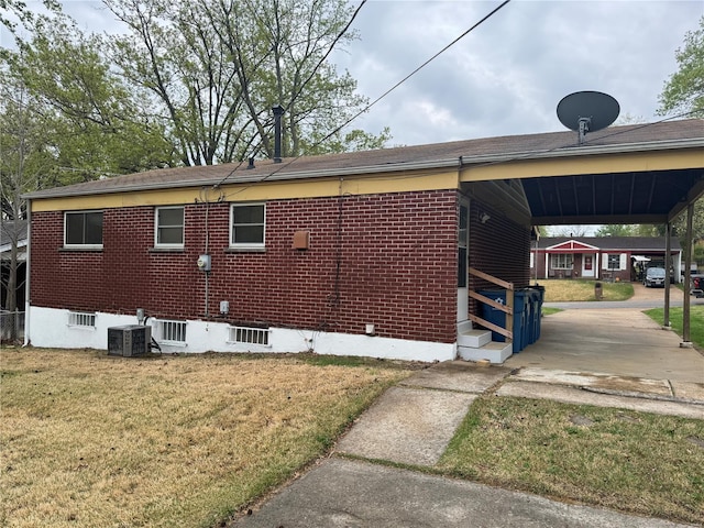 view of property exterior featuring brick siding, entry steps, a lawn, and central AC unit