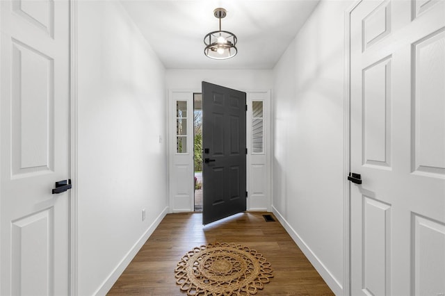 foyer entrance featuring baseboards and dark wood-style flooring