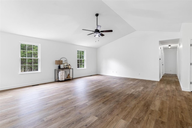 unfurnished living room featuring lofted ceiling, a ceiling fan, wood finished floors, and a healthy amount of sunlight