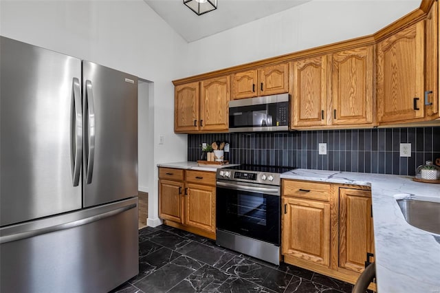 kitchen with marble finish floor, brown cabinets, decorative backsplash, and stainless steel appliances