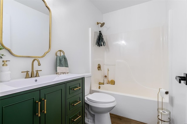 bathroom featuring toilet, vanity, wood finished floors, and  shower combination