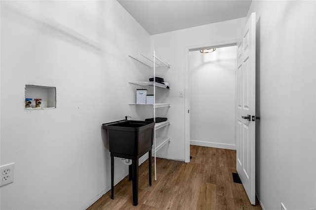 laundry area with wood finished floors, hookup for a washing machine, and laundry area