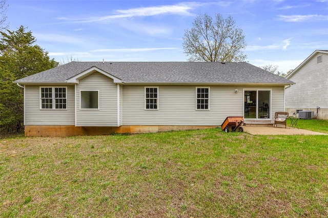 rear view of house featuring a patio area, a shingled roof, a yard, and central AC unit