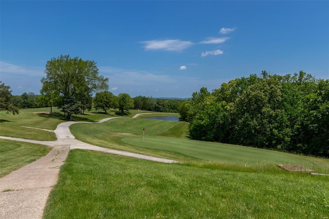 surrounding community featuring a yard and golf course view