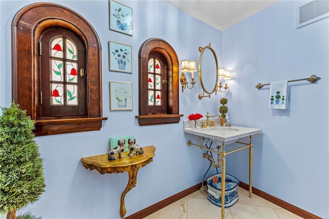 bathroom with a sink, baseboards, and visible vents