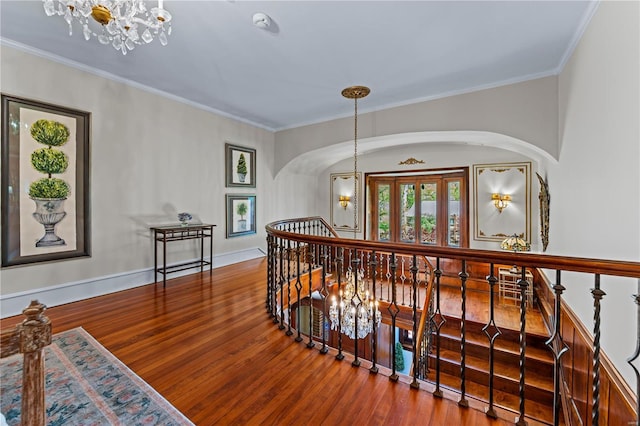 corridor featuring an upstairs landing, wood finished floors, and a notable chandelier